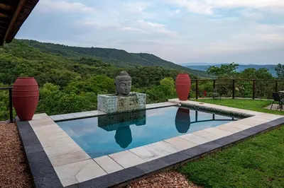 a swimming pool with a statue in the middle at The Zarafa in Hazyview