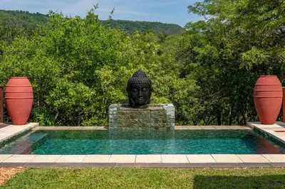 a statue of a bust sitting next to a pool at The Zarafa in Hazyview
