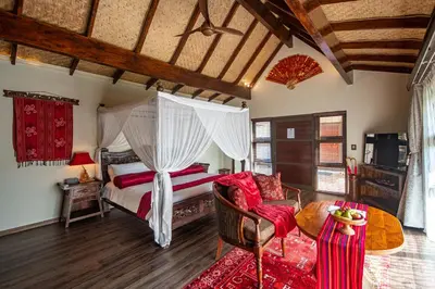 a bedroom with a bed and a couch and a table at The Zarafa in Hazyview