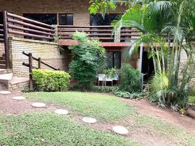 a brick building with a yard with rocks in front of it at Aloe Cottage in Nelspruit