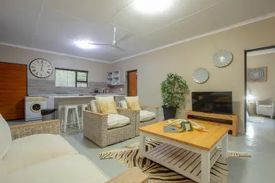 a living room with a couch and a table at Klein Paradys in Marloth Park