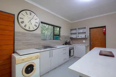 a kitchen with a large clock on the wall at Klein Paradys in Marloth Park