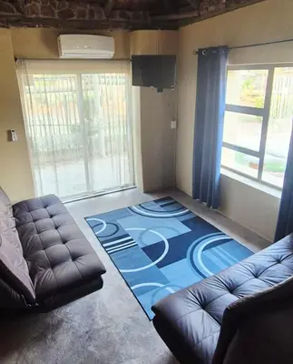 a living room with a couch and a blue carpet at Hide Away Wedding,Conference & Function Venue in Bela-Bela