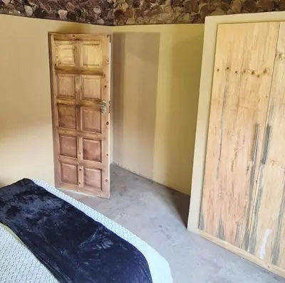 a room with an open door and a bedroom with a bed at Hide Away Wedding,Conference & Function Venue in Bela-Bela