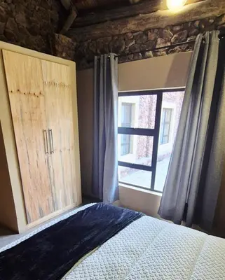 a bedroom with a bed and a window at Hide Away Wedding,Conference & Function Venue in Bela-Bela