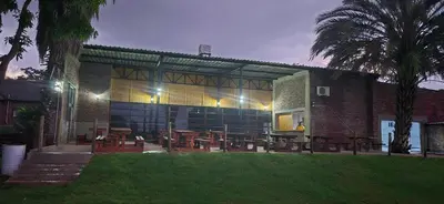 a building with tables and chairs in front of it at Hide Away Wedding,Conference & Function Venue in Bela-Bela
