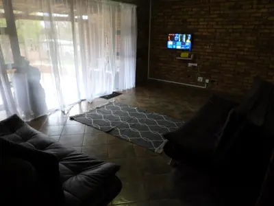 a living room with a couch and a tv at Hide Away Wedding,Conference & Function Venue in Bela-Bela