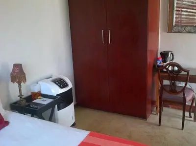 a bedroom with a bed with a stove and a chair at Monacco Guest house in Erasmus