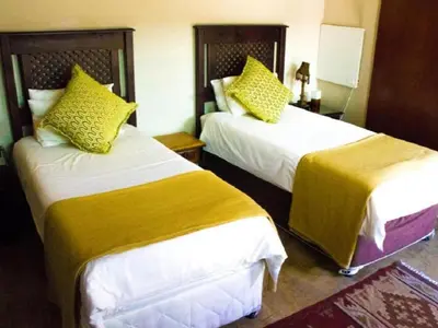a hotel room with two beds with yellow pillows at Monacco Guest house in Erasmus