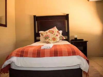a bedroom with a bed with a pillow on it at Monacco Guest house in Erasmus