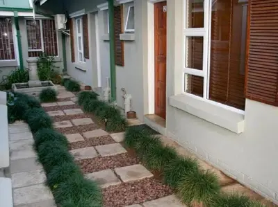 a house with a garden with plants on the side of it at Monacco Guest house in Erasmus