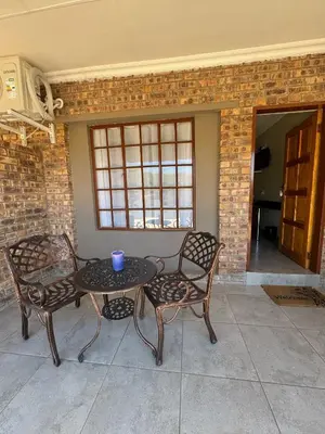 a patio with a table and chairs and a brick wall at Thabazimbi Country Lodge in Thabazimbi