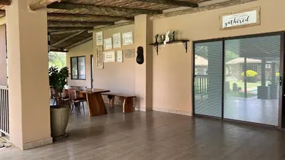 a room with a table and a door to a restaurant at Thabazimbi Country Lodge in Thabazimbi
