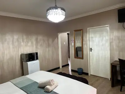 a bedroom with a bed with two towels on it at Thabazimbi Country Lodge in Thabazimbi