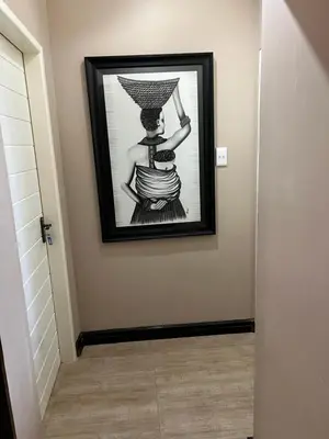 a picture of a woman in a dress on a wall at Thabazimbi Country Lodge in Thabazimbi
