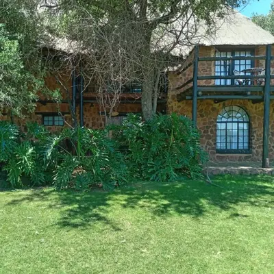 a brick house with a tree in front of it at Glen Afric Country Lodge in Hartbeespoort