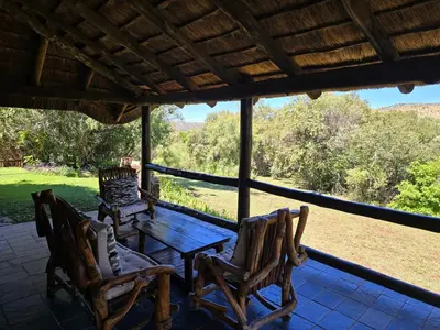 a table and chairs on a porch with a view at Glen Afric Country Lodge in Hartbeespoort
