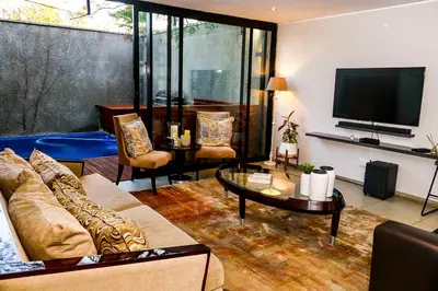 a living room with a couch and a tv at Ten On Lane in Polokwane
