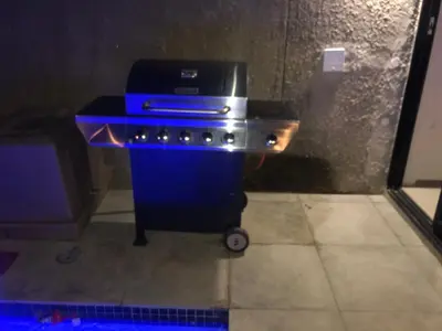 a gas grill in a kitchen with blue lights at Ten On Lane in Polokwane