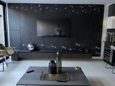 a living room with a tv on a black wall at Ten On Lane in Polokwane