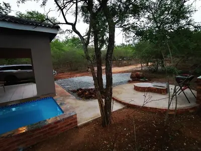 a swimming pool next to a house with a tree at 3714 @Ribbok in Marloth Park