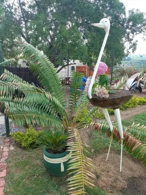 a statue of a bird standing next to a plant at JB Countrylife Accommodation in Centurion