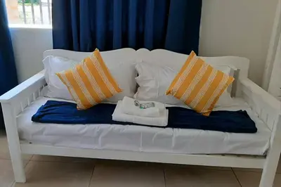 a white bench with pillows and towels on it at Kruger Southern Cross in Malelane