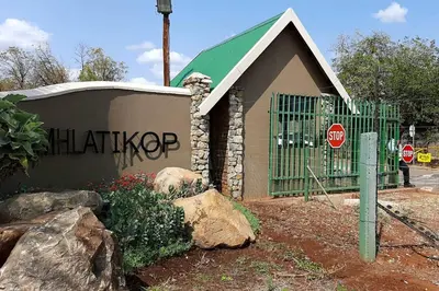 a gate in front of a building with a stop sign at Kruger Southern Cross in Malelane