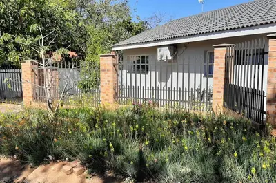 a house with a fence in front of it at Kruger Southern Cross in Malelane