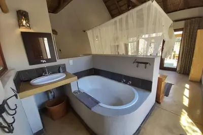 a bathroom with a bath tub and a sink at 13 Raptors Lodge in Hoedspruit
