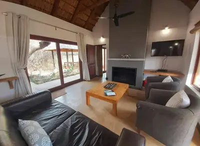 a living room with a couch and a table at 13 Raptors Lodge in Hoedspruit
