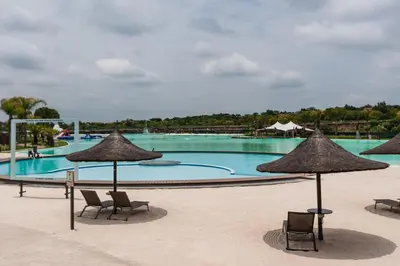 a large swimming pool with chairs and umbrellas at #Alimama Spaces Blyde Haven in Pretoria