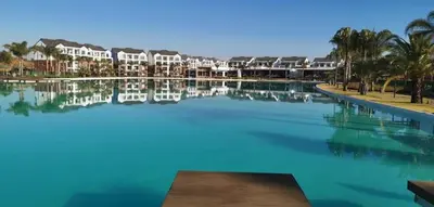 a large pool of water with houses and palm trees at #Alimama Spaces Blyde Haven in Pretoria