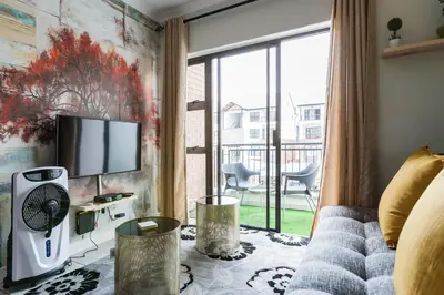 a living room with a couch and a tv at #Alimama Spaces Blyde Haven in Pretoria