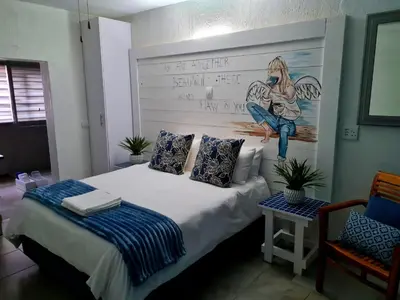 a bedroom with a bed with a painting on the wall at Forget me not Selfcatering Apartments in Nelspruit