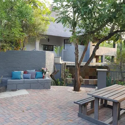 a picnic table and a bench in front of a house at Forget me not Selfcatering Apartments in Nelspruit