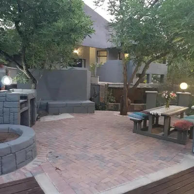 a patio with a bench and a table and trees at Forget me not Selfcatering Apartments in Nelspruit