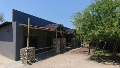 a black building with trees in front of it at SVH Bush Lodge in Marloth Park