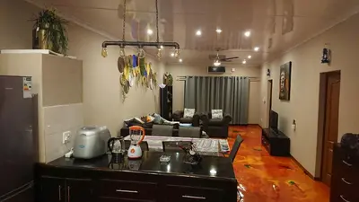 a kitchen and living room with a couch at SVH Bush Lodge in Marloth Park