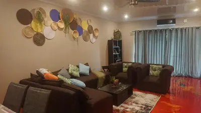 a living room with couches and hats on the wall at SVH Bush Lodge in Marloth Park
