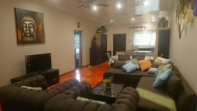a living room with two couches and a television at SVH Bush Lodge in Marloth Park