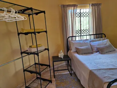a bedroom with a bed and a bunk bed at Rhumbini Lodge in Malamulele
