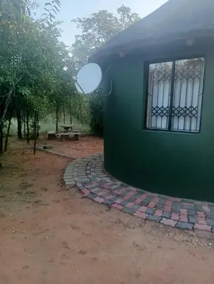 a green building with a window on the side of it at Rhumbini Lodge in Malamulele