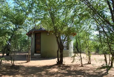 a small building in the middle of some trees at Rhumbini Lodge in Malamulele