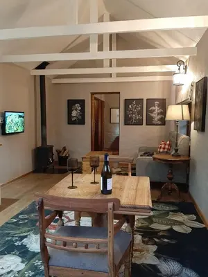 a living room with a table with a bottle of wine at Critchley Hackle - Leisure rooms in Dullstroom