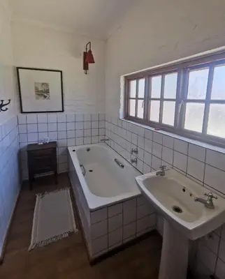 a bathroom with two sinks and a bath tub at Critchley Hackle - Leisure rooms in Dullstroom