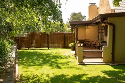 a backyard with a fence and a grass yard at Camdeboo Place in Dullstroom