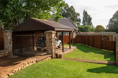 a garage with a fence in a yard at Camdeboo Place in Dullstroom