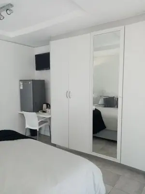 a bedroom with a large white closet with a mirror at Lior-Gil accommodation- in Kempton Park