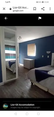 a bedroom with a mirror and a blue wall at Lior-Gil accommodation- in Kempton Park